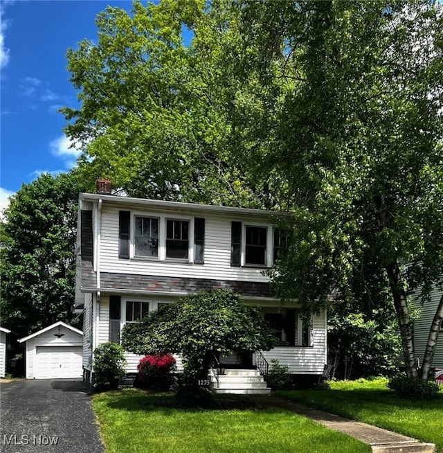 1275 Hollywood, Warren, OH 44483 - view of front of home featuring an outdoor structure, a detached garage, a front lawn, and asphalt driveway