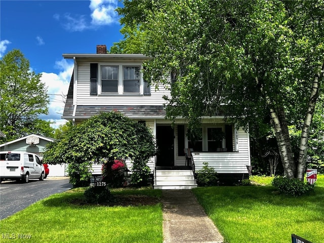 1275 Hollywood, Warren, OH 44483 - view of front facade featuring covered porch, a chimney, a front yard, and a detached garage
