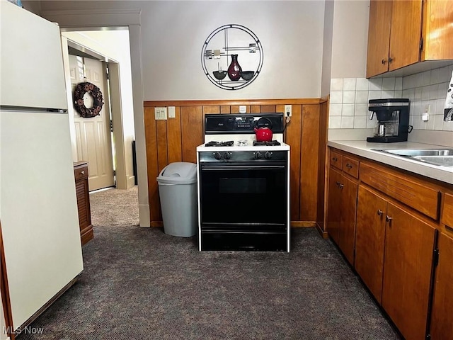 1275 Hollywood, Warren, OH 44483 - kitchen featuring freestanding refrigerator, gas range, dark carpet, light countertops, and a wainscoted wall