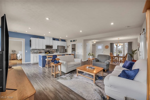 living area with baseboards, recessed lighting, a chandelier, and wood finished floors
