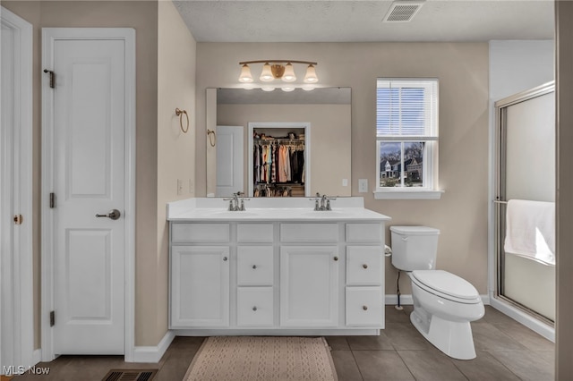 bathroom with double vanity, visible vents, a sink, and toilet