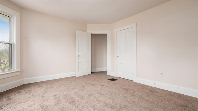 spare room with baseboards, carpet floors, and plenty of natural light