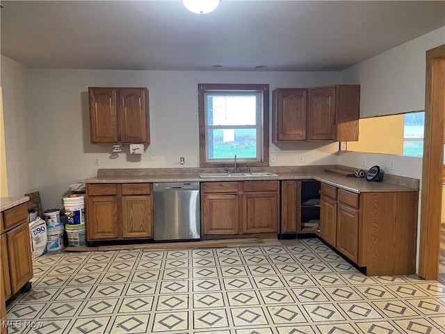 kitchen featuring dishwasher, light countertops, a sink, and light floors