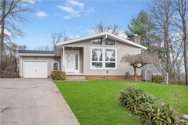 70 Iroquois Trl, Malvern, OH 44644 - view of front of home featuring a chimney, a garage, concrete driveway, and a front yard