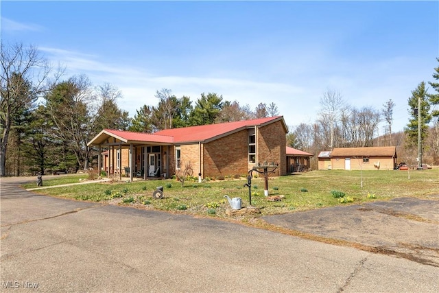 view of front of house featuring brick siding and a front lawn