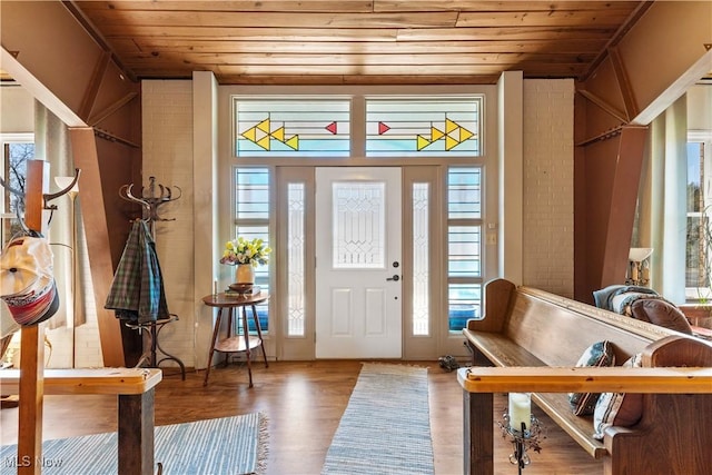 entryway featuring wood finished floors, a healthy amount of sunlight, and wooden ceiling