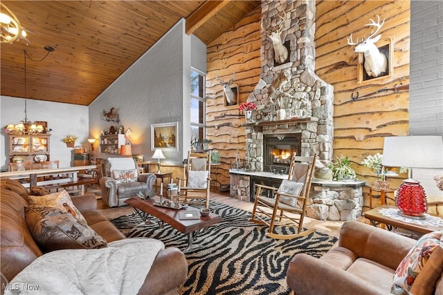 living area with a stone fireplace, a notable chandelier, high vaulted ceiling, and wood ceiling