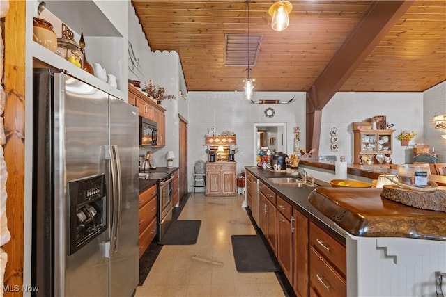 kitchen with a sink, stainless steel appliances, and dark countertops