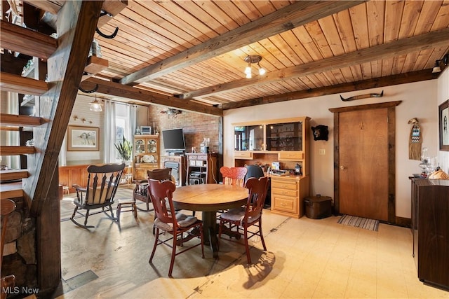 dining area featuring wood ceiling, beamed ceiling, and light floors