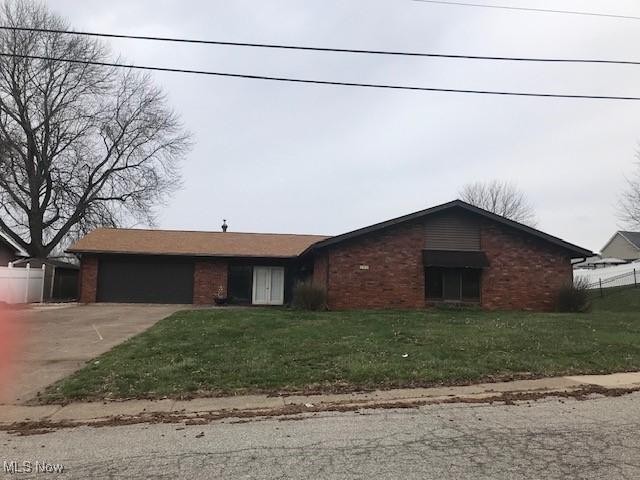 157 Highland Hills Dr, Follansbee, WV 26037 - ranch-style house featuring driveway, an attached garage, brick siding, and a front yard