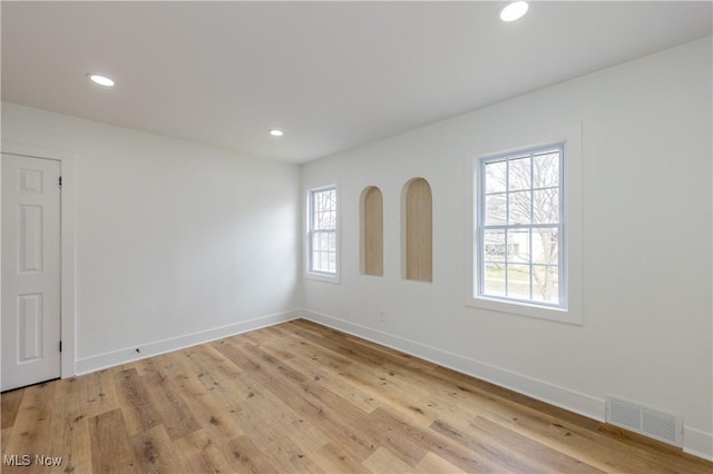 empty room with recessed lighting, light wood-style floors, baseboards, and visible vents