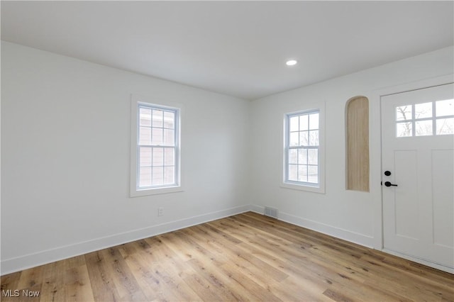 foyer entrance with plenty of natural light, baseboards, and visible vents