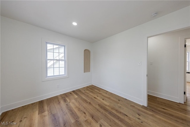 unfurnished room featuring baseboards, wood finished floors, and recessed lighting