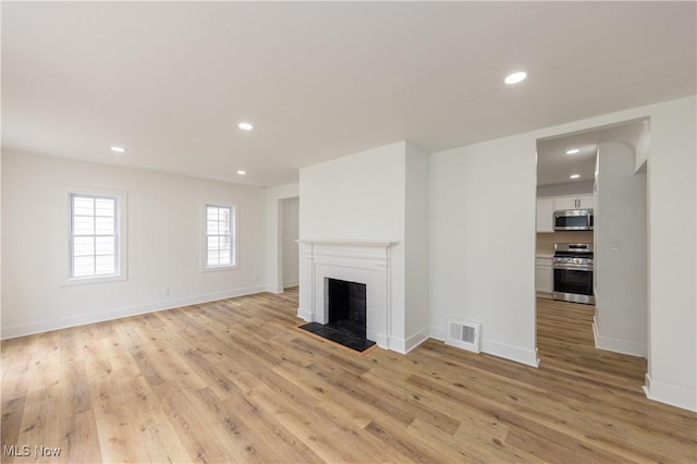 unfurnished living room with recessed lighting, light wood-style floors, and visible vents
