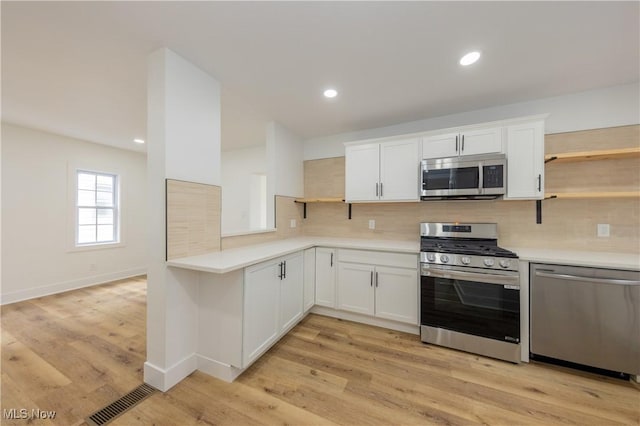 kitchen featuring light countertops, appliances with stainless steel finishes, and open shelves