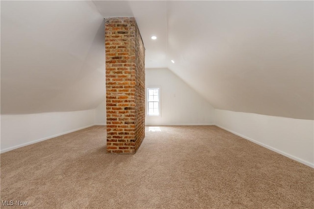 additional living space featuring baseboards, lofted ceiling, and carpet flooring