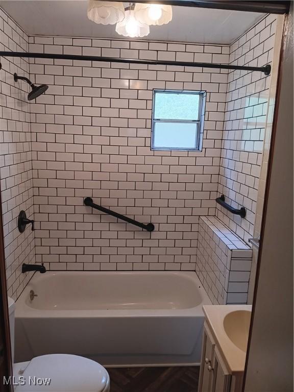 full bath featuring toilet, vanity, and washtub / shower combination