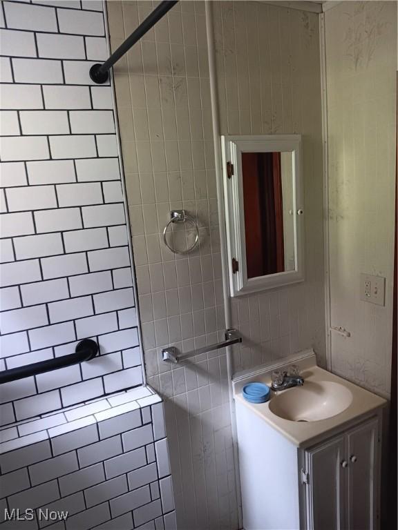 full bath with vanity and tiled shower