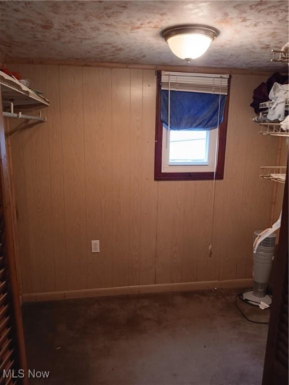 interior space with baseboards and wood walls