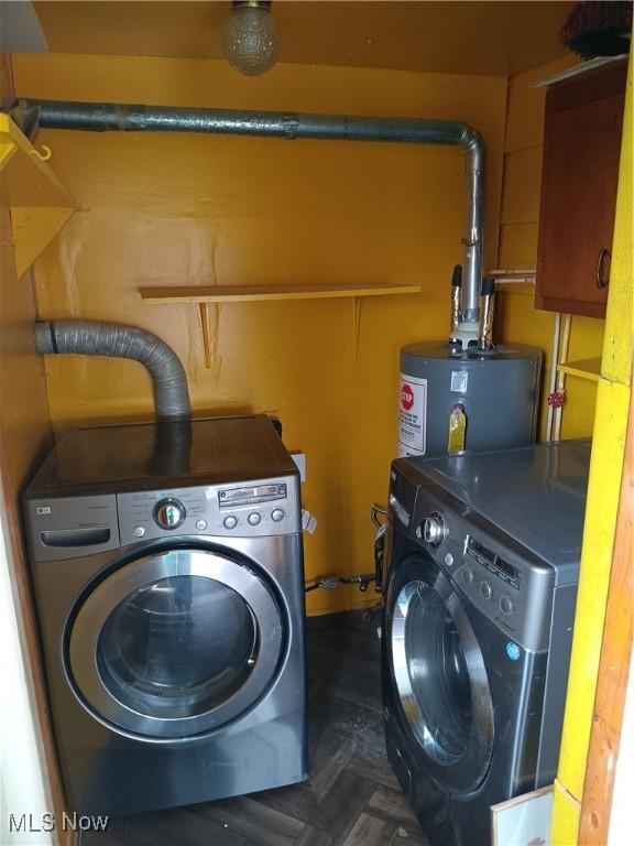 clothes washing area featuring independent washer and dryer, water heater, and laundry area