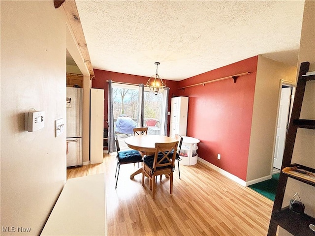 380 Sunshine Park Rd, Steubenville, OH 43952 - dining area featuring baseboards, a textured ceiling, light wood-style flooring, and a notable chandelier