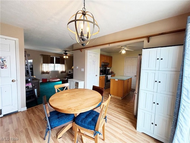 380 Sunshine Park Rd, Steubenville, OH 43952 - dining space featuring baseboards, a textured ceiling, ceiling fan with notable chandelier, and light wood finished floors