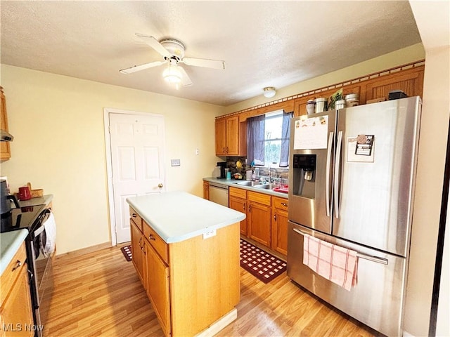 380 Sunshine Park Rd, Steubenville, OH 43952 - kitchen featuring a ceiling fan, appliances with stainless steel finishes, light wood-style floors, and brown cabinets