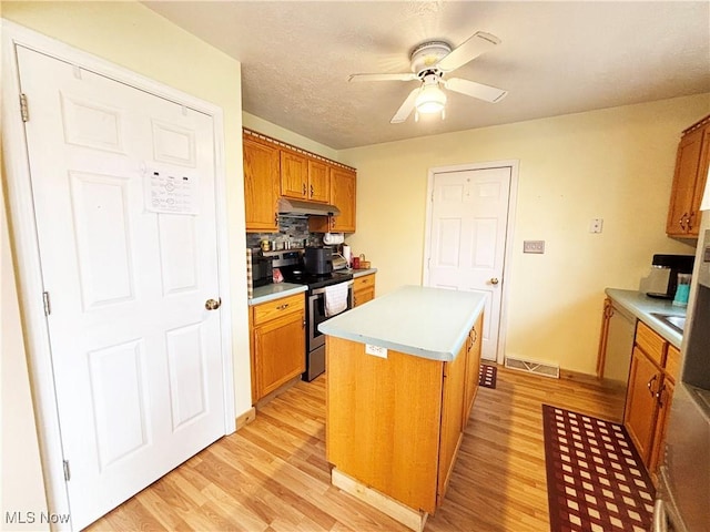 380 Sunshine Park Rd, Steubenville, OH 43952 - kitchen featuring light wood-type flooring, under cabinet range hood, stainless steel range with electric cooktop, ceiling fan, and visible vents