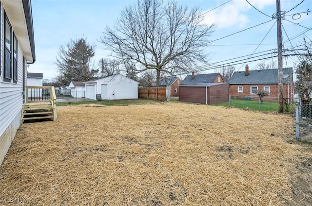 view of yard with fence, an outdoor structure, and a detached garage