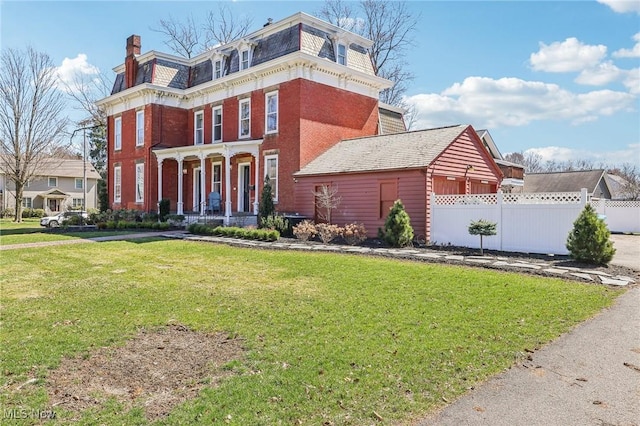 500 S Main St, Poland, OH 44514 - view of front facade featuring fence, mansard roof, a front yard, brick siding, and a chimney