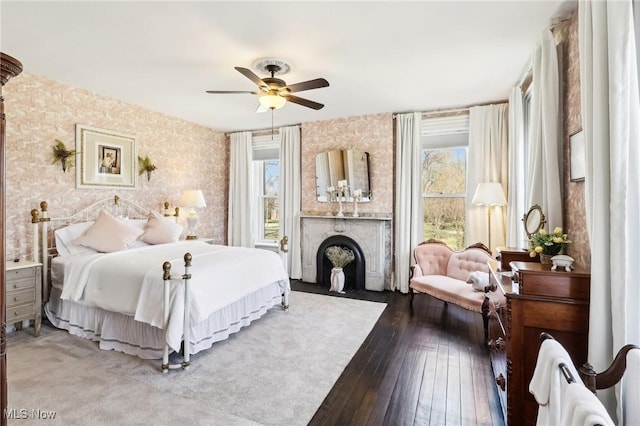 500 S Main St, Poland, OH 44514 - bedroom featuring a fireplace with flush hearth, ceiling fan, wallpapered walls, and wood-type flooring