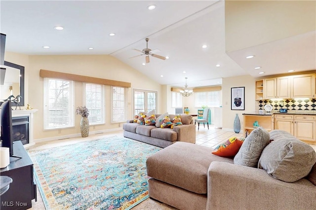 living room with light tile patterned flooring, recessed lighting, lofted ceiling, ceiling fan with notable chandelier, and a glass covered fireplace