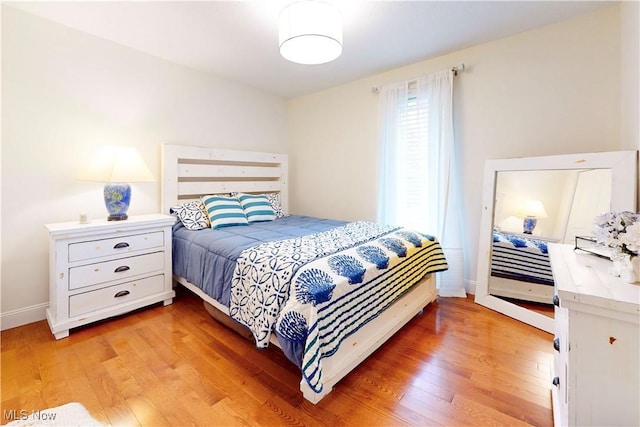 bedroom with baseboards and light wood-style floors