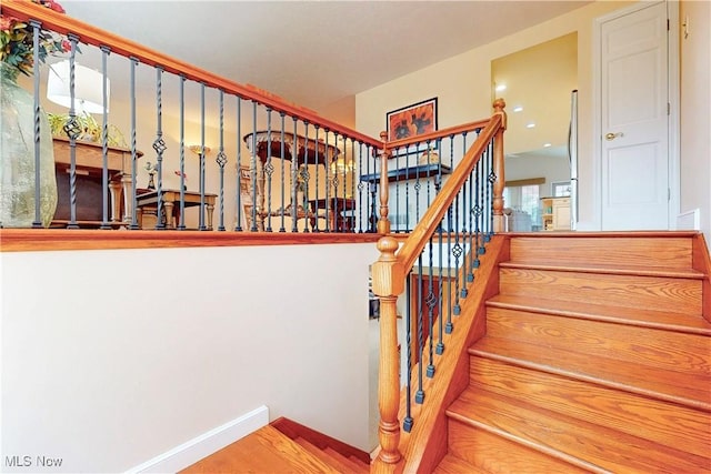 stairway featuring baseboards and wood finished floors