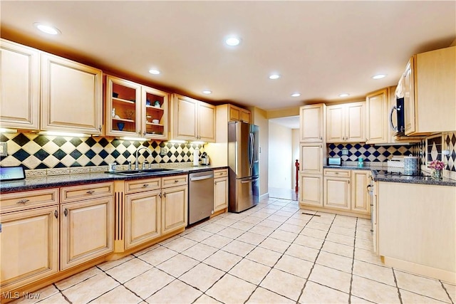 kitchen with stainless steel appliances, recessed lighting, glass insert cabinets, a sink, and light tile patterned floors