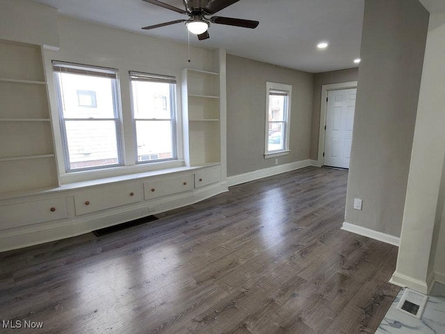 unfurnished room featuring built in shelves, visible vents, baseboards, and ceiling fan
