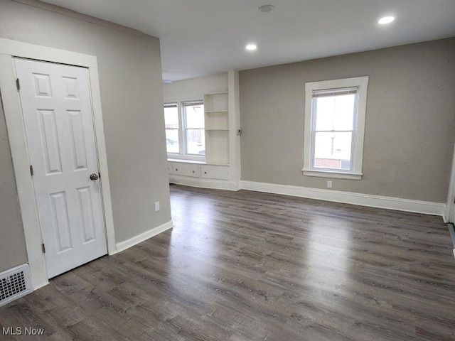 empty room with recessed lighting, visible vents, baseboards, and dark wood finished floors