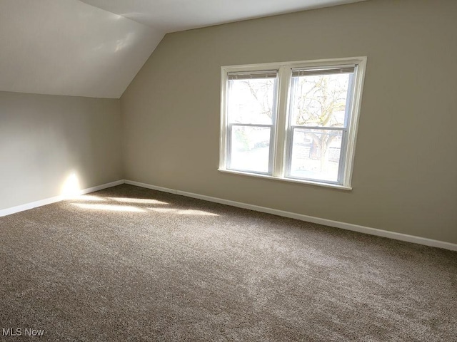 bonus room with baseboards, lofted ceiling, and carpet