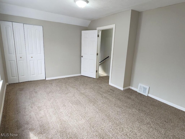unfurnished bedroom with a closet, baseboards, visible vents, and carpet floors