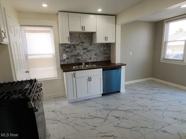 kitchen featuring wood counters, dishwasher, a sink, black gas stove, and baseboards