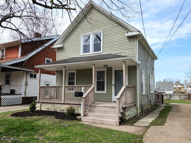 view of front of property featuring a porch, a front lawn, and a chimney