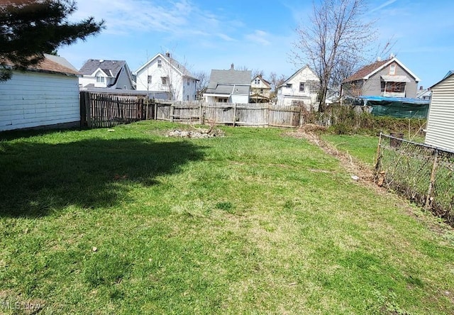 view of yard with a fenced backyard and a residential view