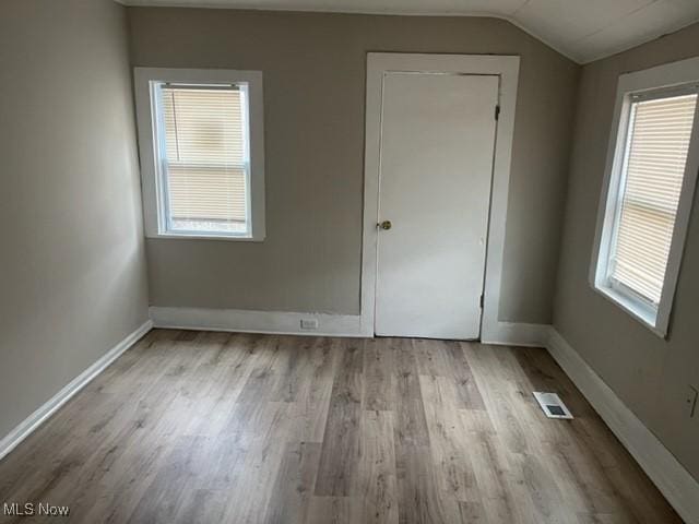 1900 Lamoille Ct, Cleveland, OH 44113 - unfurnished bedroom with wood finished floors, baseboards, and vaulted ceiling