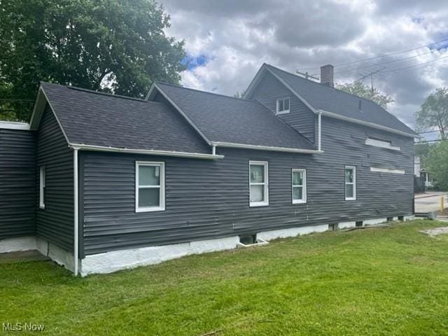 1900 Lamoille Ct, Cleveland, OH 44113 - view of side of property with a yard, roof with shingles, and a chimney