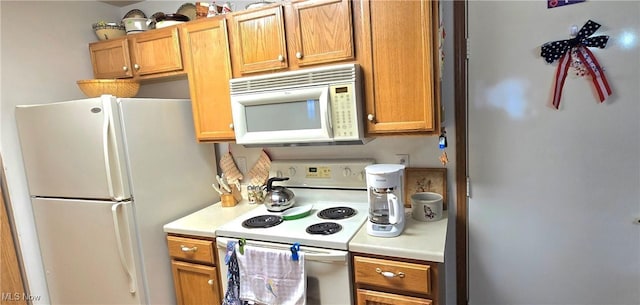 kitchen featuring light countertops, brown cabinetry, and white appliances