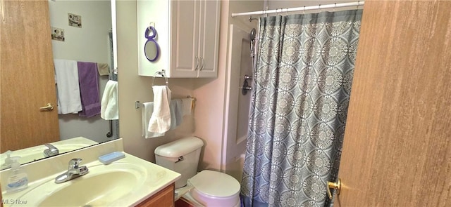 bathroom with toilet, vanity, and curtained shower