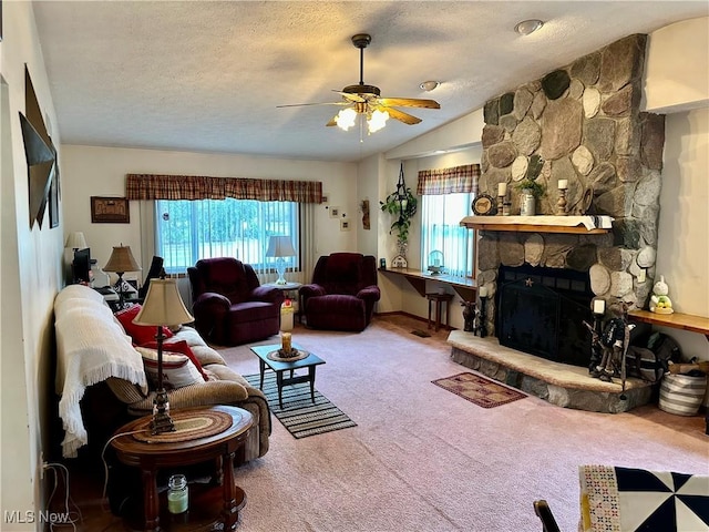 carpeted living area with lofted ceiling, a textured ceiling, a ceiling fan, and a fireplace
