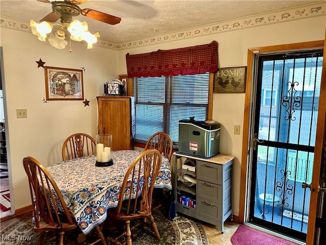 dining area with a textured ceiling, a ceiling fan, and baseboards
