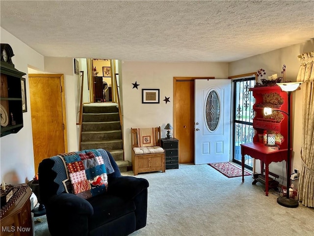 living room with stairway, carpet flooring, and a textured ceiling
