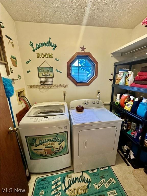 laundry area with washer and dryer, a textured ceiling, and laundry area